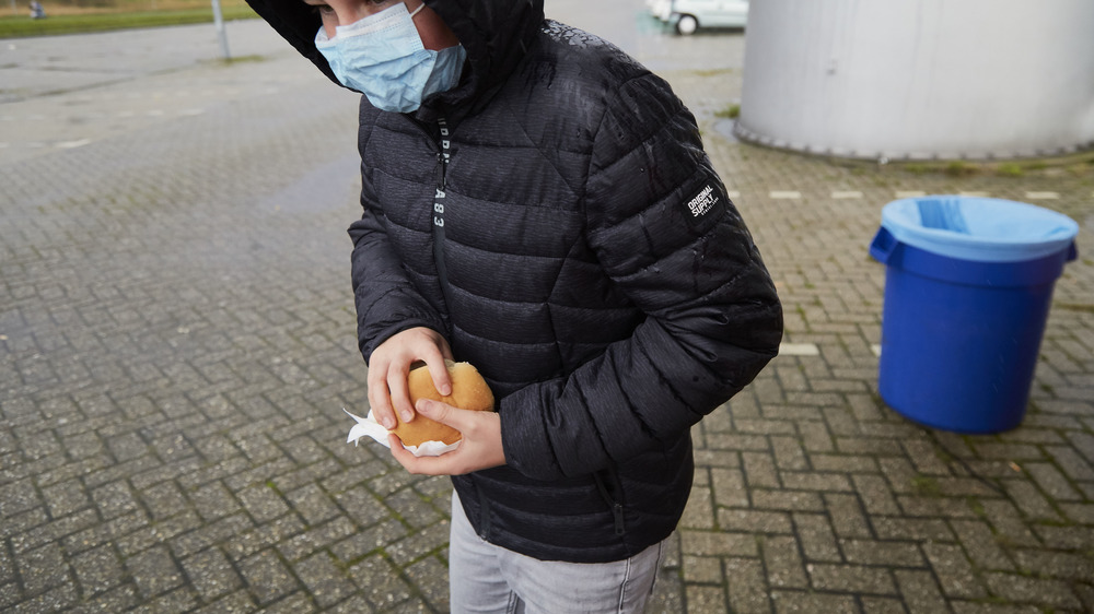 Boy in Netherlands clutching sandwich at customs site