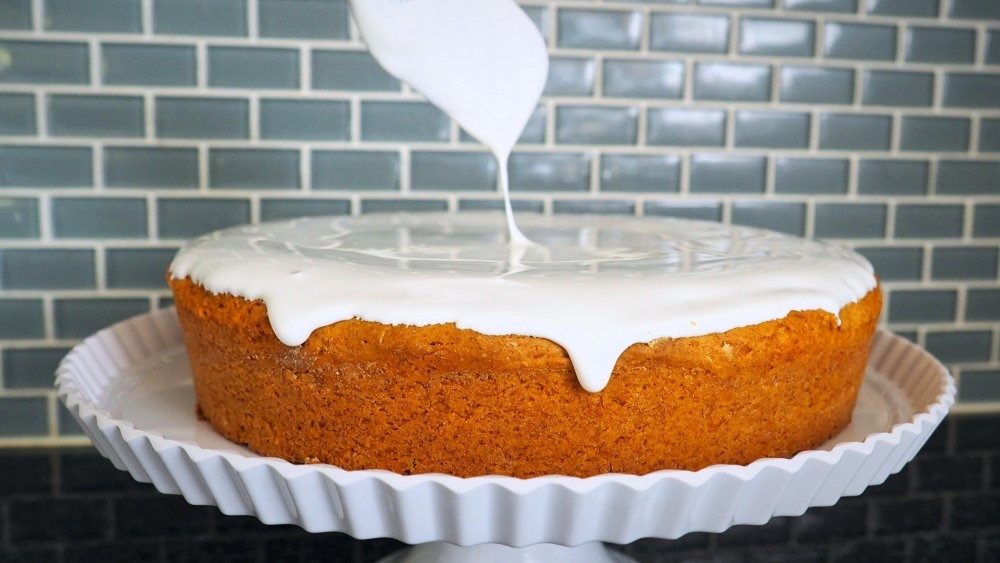 spreading frosting on pumpkin cake