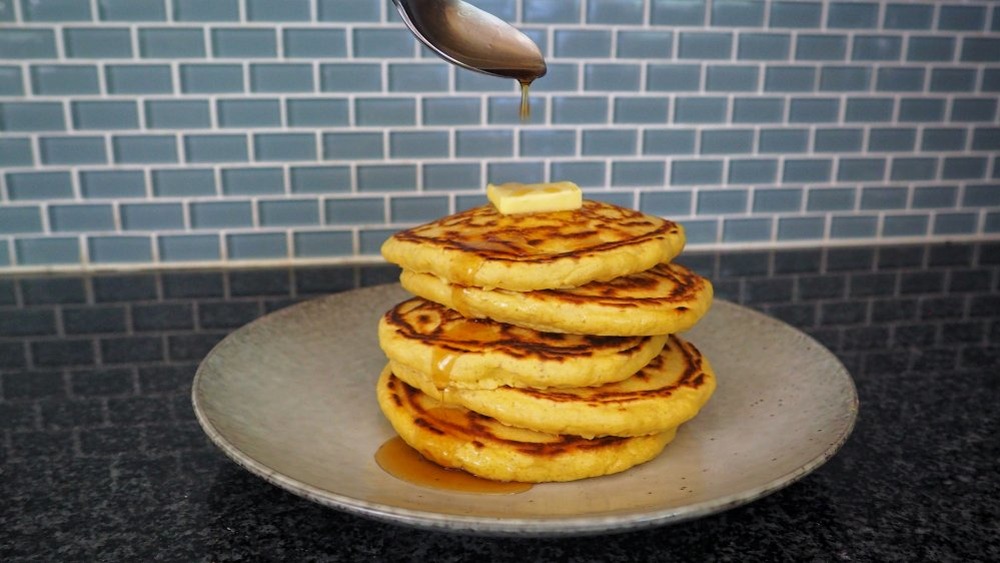 pouring syrup on pancakes