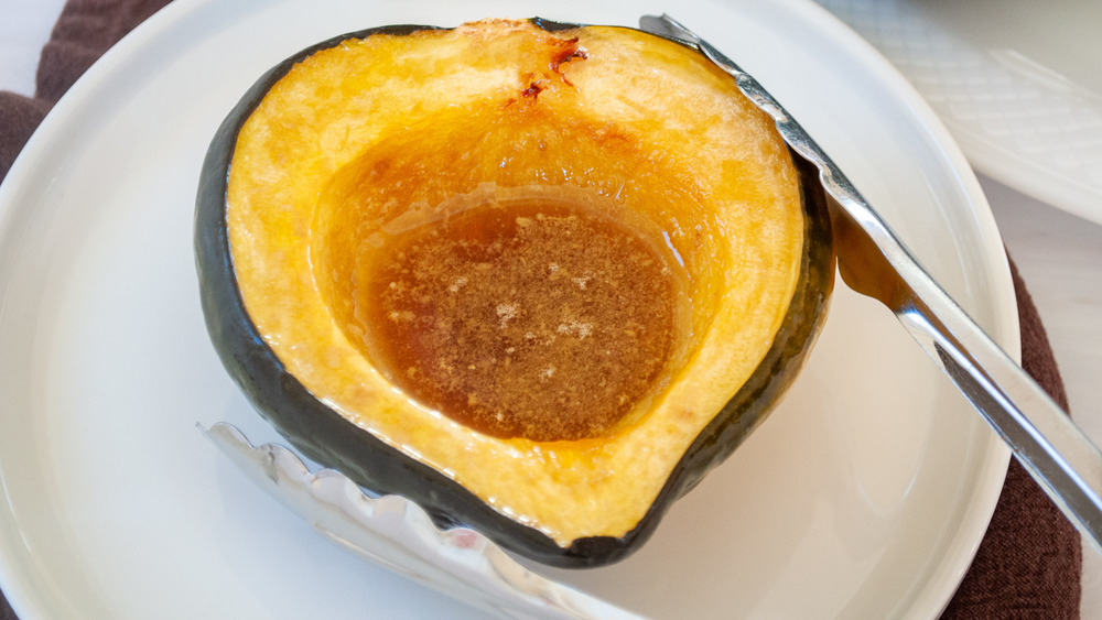 tongs serving acorn squash on plate