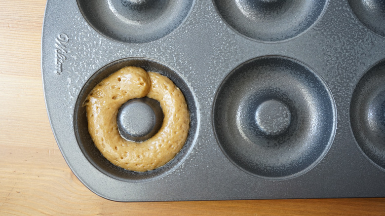 Filling pan halfway apple cider donut