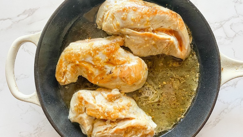 chicken breasts in skillet with honey garlic sauce