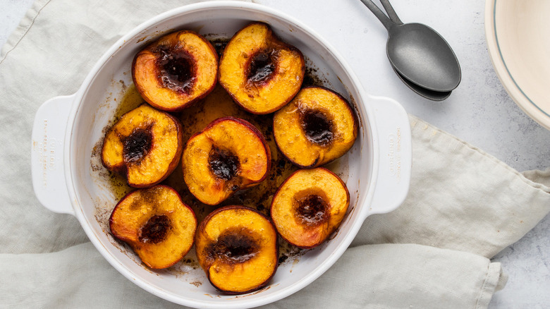 Baked peaches in dish with spoon