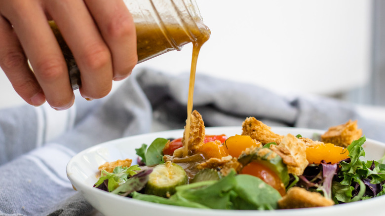 pouring dressing on salad