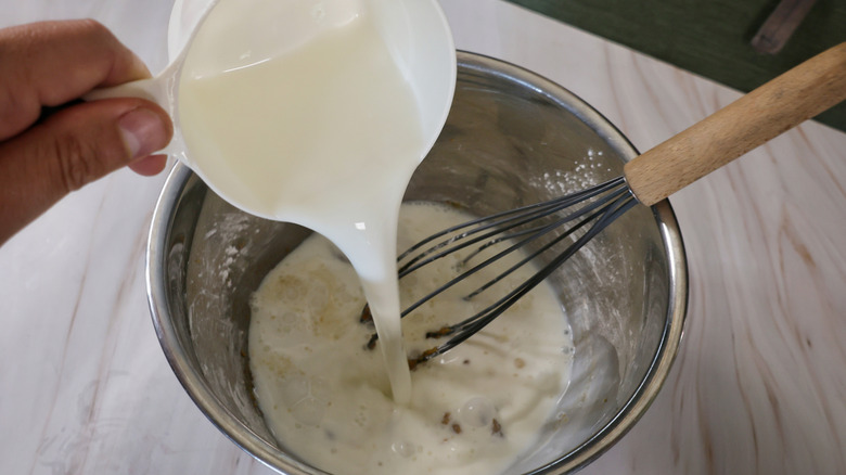 pouring milk into mixing bowl