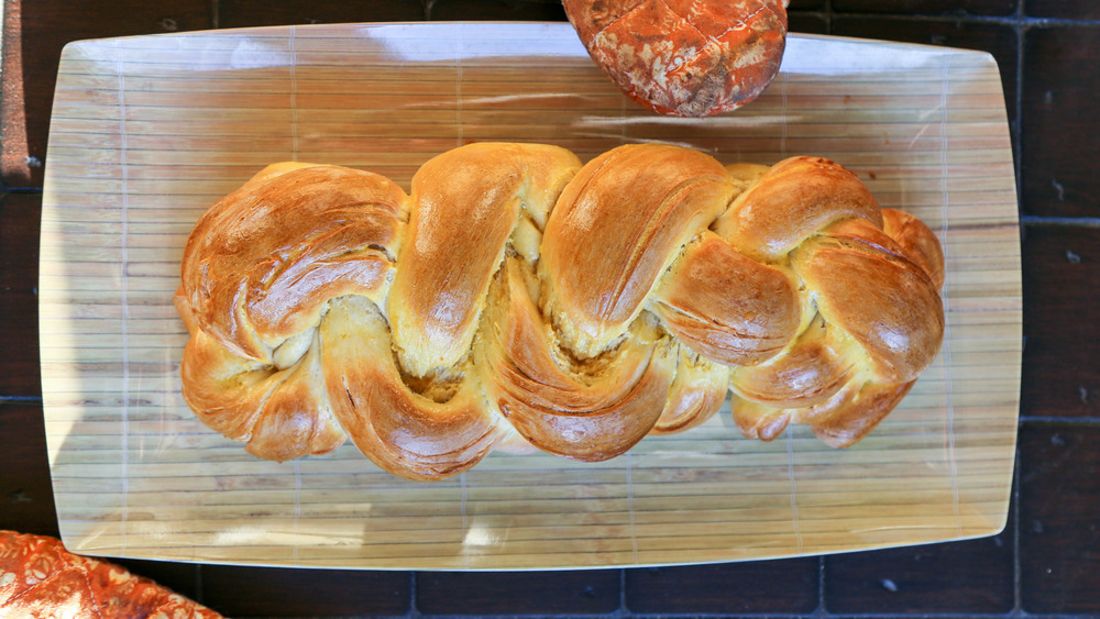 braided challah on cutting board