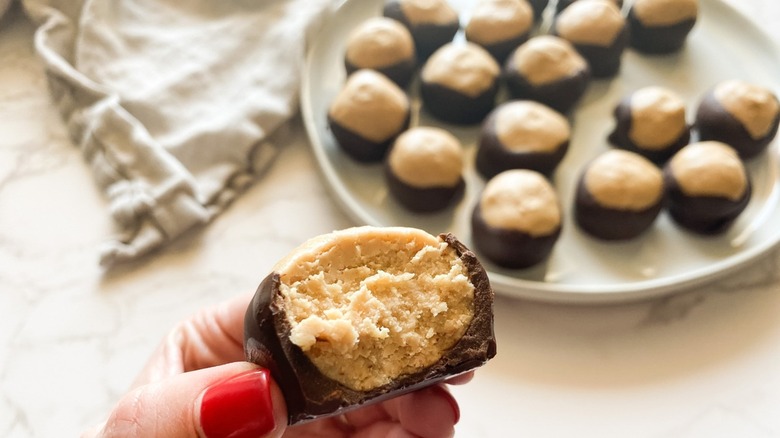 A woman holding a buckeye cookie.