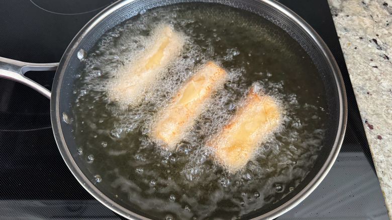 egg rolls frying in oil