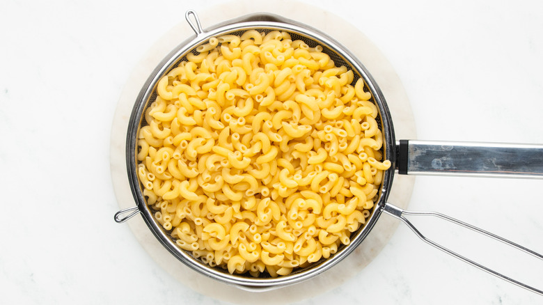 cooked macaroni in strainer