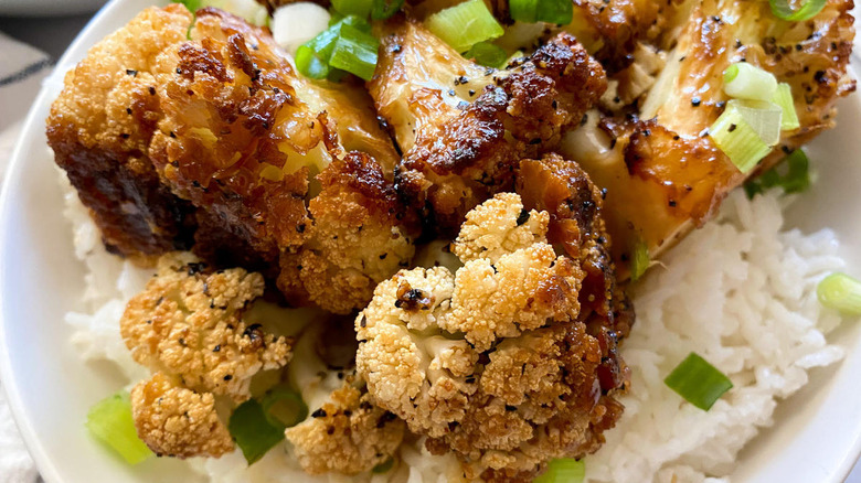 plate of cauliflower adobo on rice with green onions