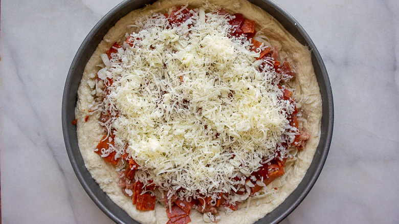 an unbaked deep dish pizza