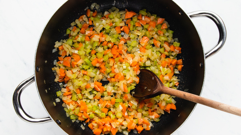 Diced vegetables frying in soup pot