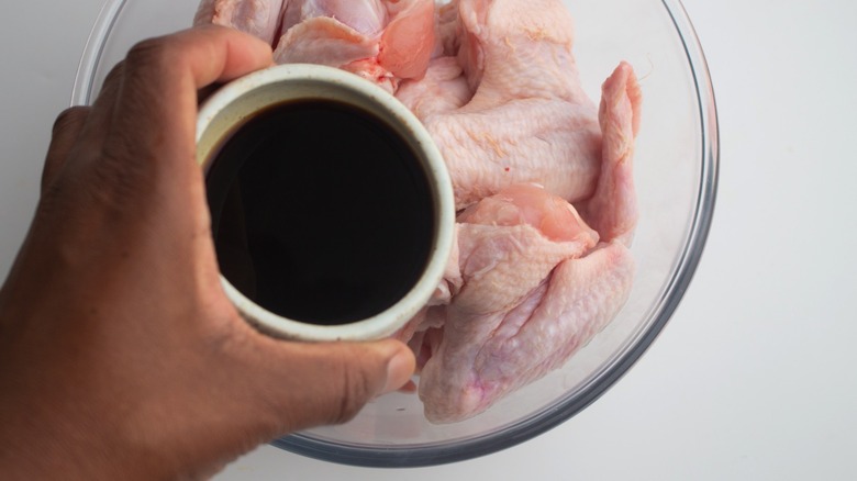 Pouring marinade on wings