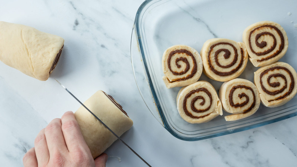 Slicing cinnamon roll