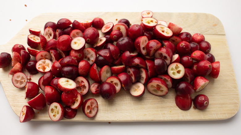 sliced cranberries on wooden board