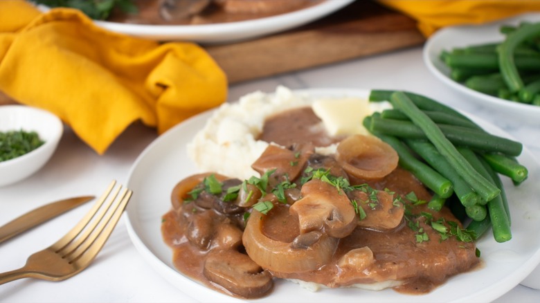 cube steak with mushroom gravy, mashed potatoes, and green beans