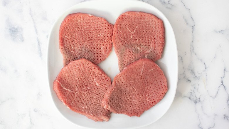 cubed steaks on a white plate