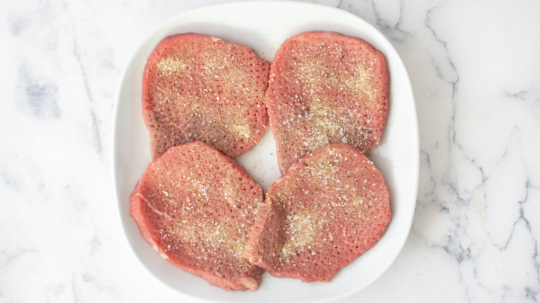 seasoned cubed steaks on a white plate