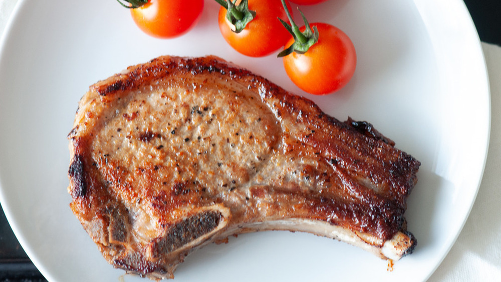 pork chops on plate with cherry tomatoes