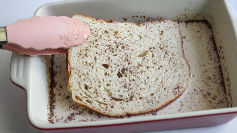 tongs dunking bread in batter