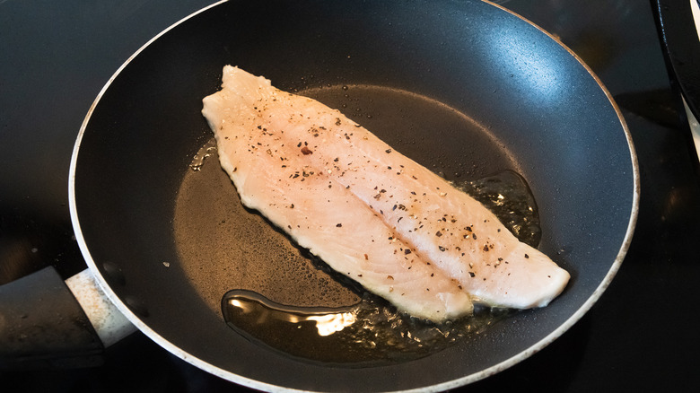 fish fillets frying in pan