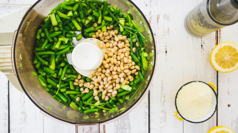 food processor with garlic scapes and pine nuts