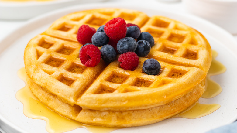 Two waffles with syrup and berries