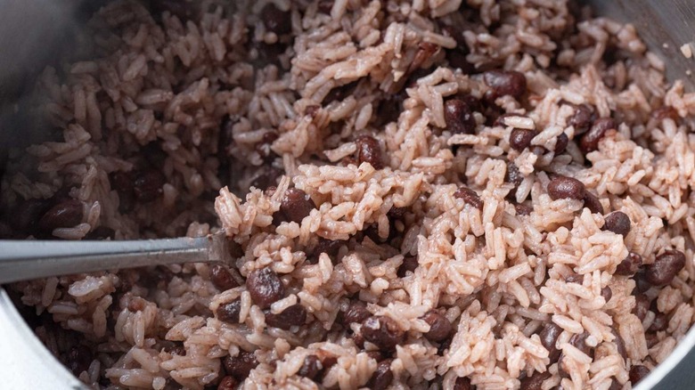 fork fluffing rice and beans in pan