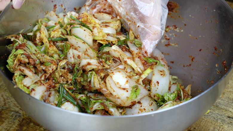 Mixing kimchi ingredients in bowl