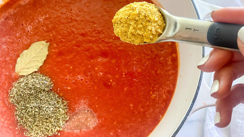 adding spices to the sauce