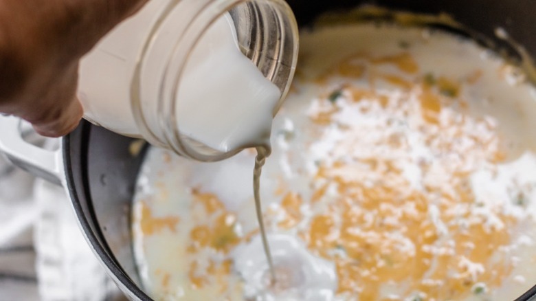 pouring milk into queso