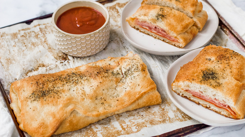 slices of stromboli with container of pizza sauce for dipping 