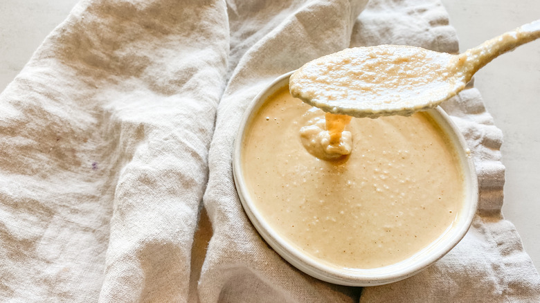 tahini dripping from spoon into bowl