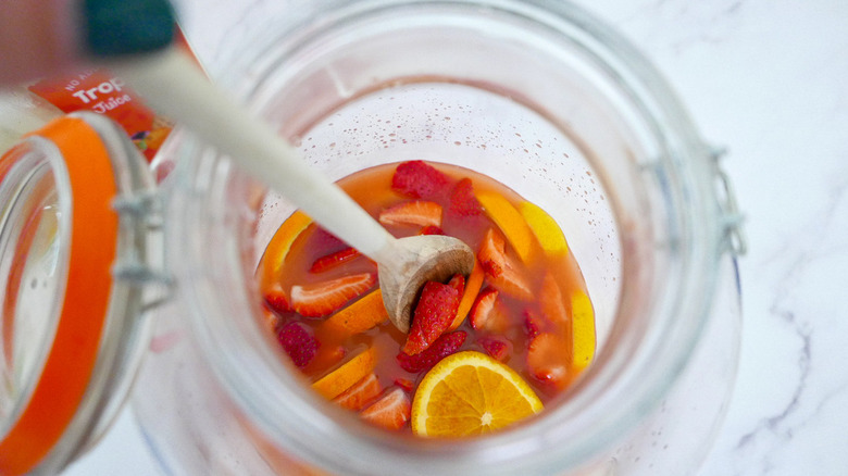 spoon stirring fruit in jar