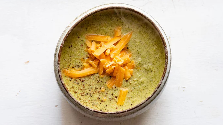 A bowl of broccoli soup topped with cheese