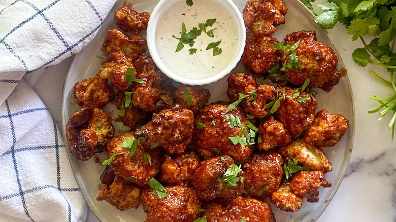 A plate of cauliflower wings with a dip