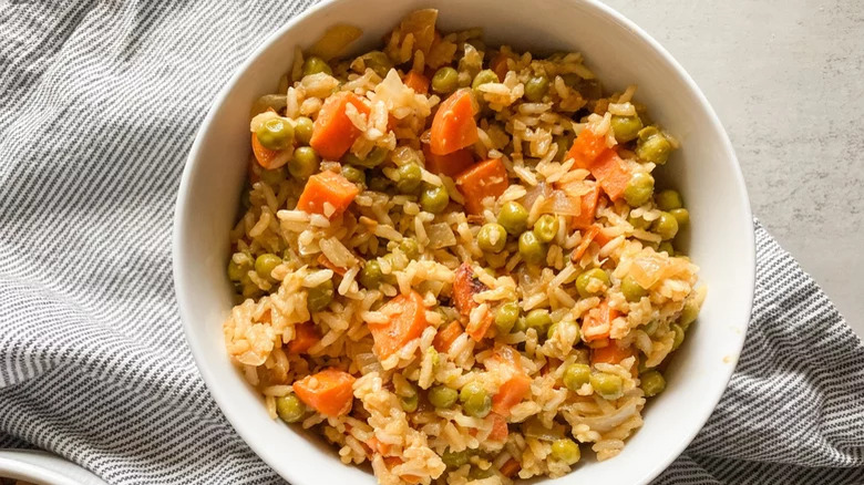 A bowl of fried rice with vegetables