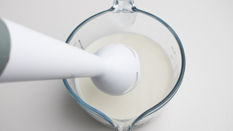 Frothing the milk with an immersion blender