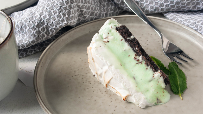 slice of baked Alaska cake with mint ice cream layer on plate