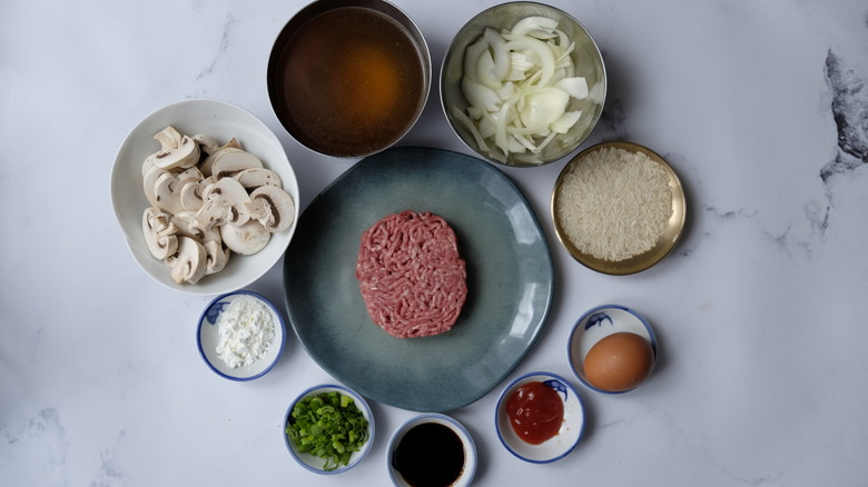 Loco moco ingredients in small bowls, with ground beef on plate