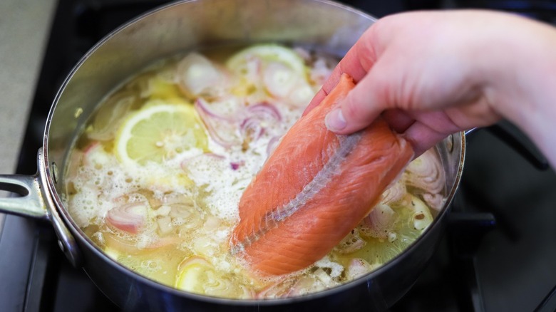 adding salmon filet to broth