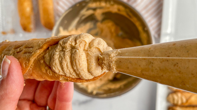 piping filling into cannoli