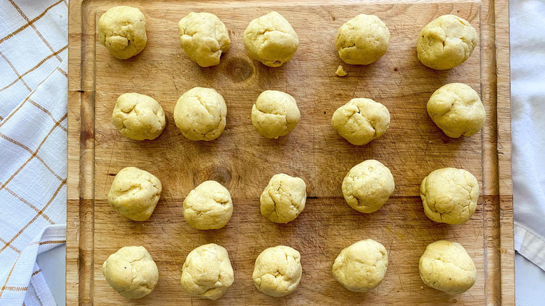 Balls of masa on wooden cutting board