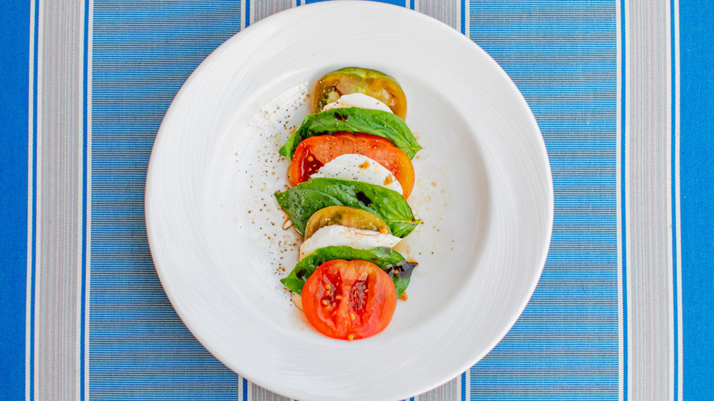 plate of Caprese salad with mozzarella, tomatoes and basil