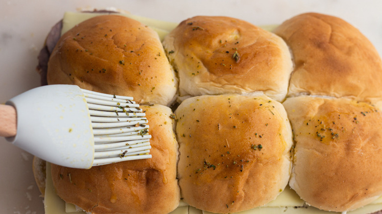 brushing butter on roast beef sliders