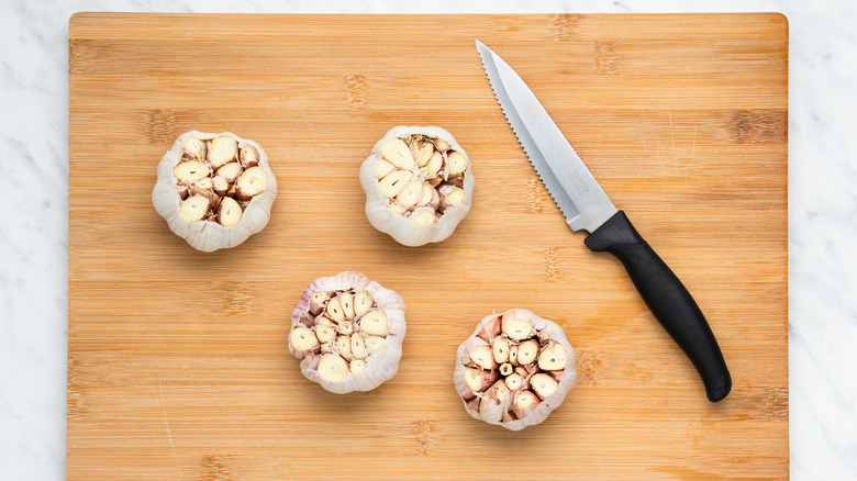 garlic bulbs sliced open on cutting board