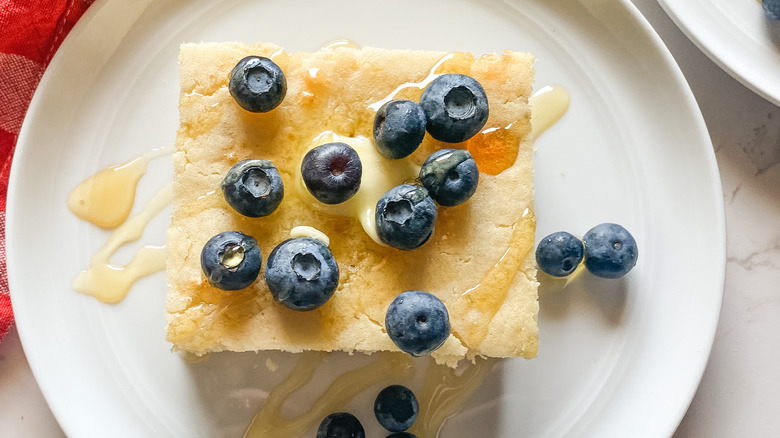 Close up, sheet pancake with blueberries, butter, and syrup