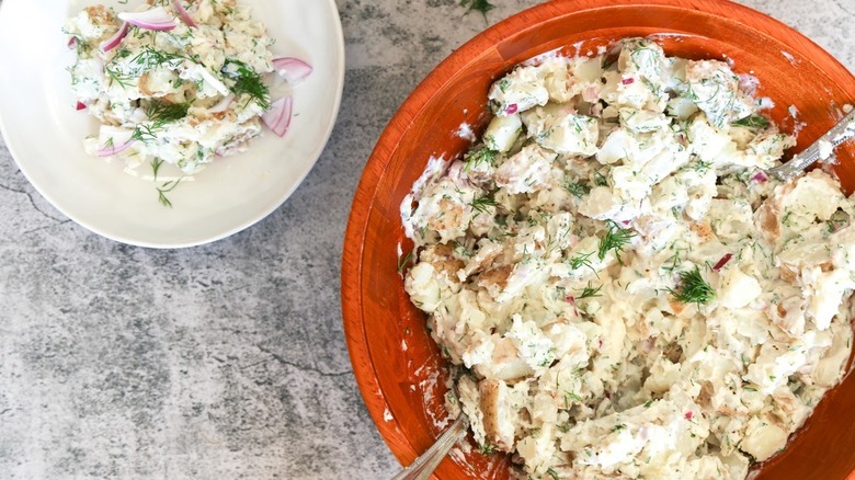 bowl of potato salad with onions and dill 