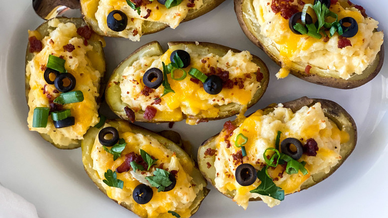 loaded twice-baked potatoes topped with onions, cheese, bacon bits, and black olives