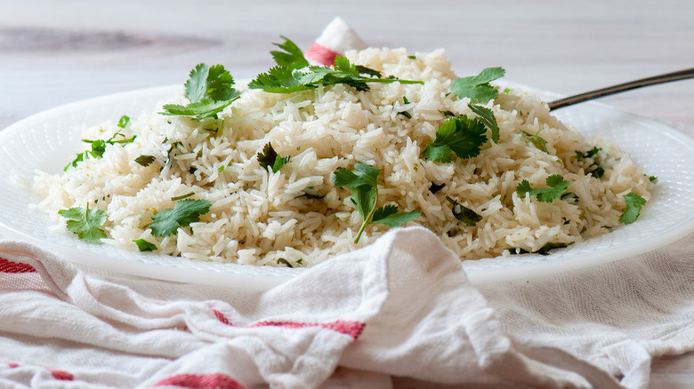 plate brimming with white jasmine rice and cilantro flakes